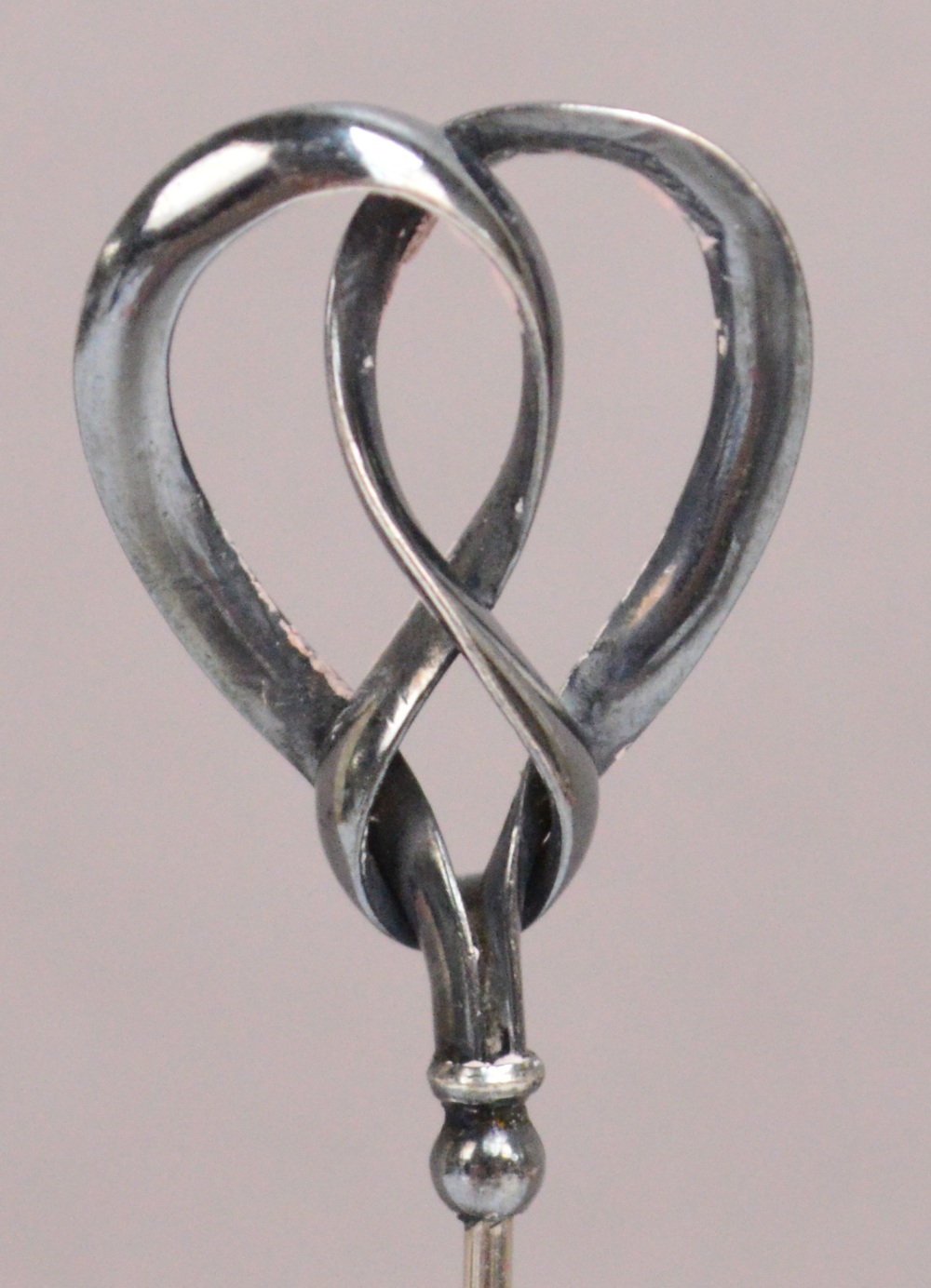A Charles Horner hallmarked silver hat pin of abstract form with double loop ribbon, Chester 1908,
