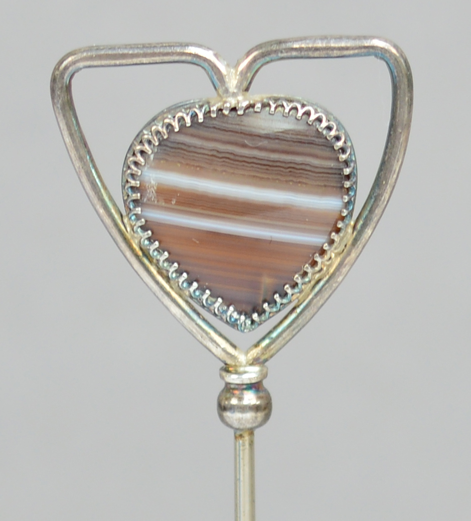An Edward VII hallmarked silver hat pin in the form of a silver wire triangular heart frame