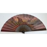 A late 19th century large folding fan with ebonised gilt heightened guards and sticks with floral