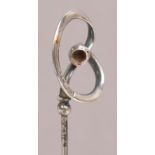 A Charles Horner hallmarked silver hat pin of abstract looping form with hollow ball, Chester 1909,