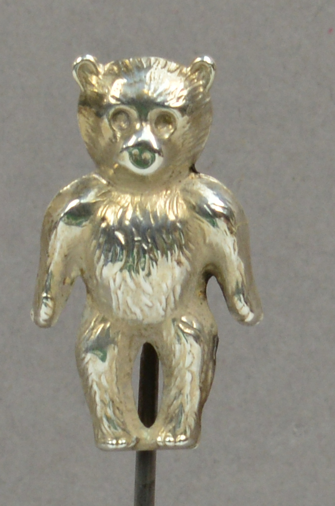 A silver hat pin in the form of a standing teddy bear, stamped "Silver", the hinged head height 3cm,