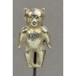 A silver hat pin in the form of a standing teddy bear, stamped "Silver", the hinged head height 3cm,