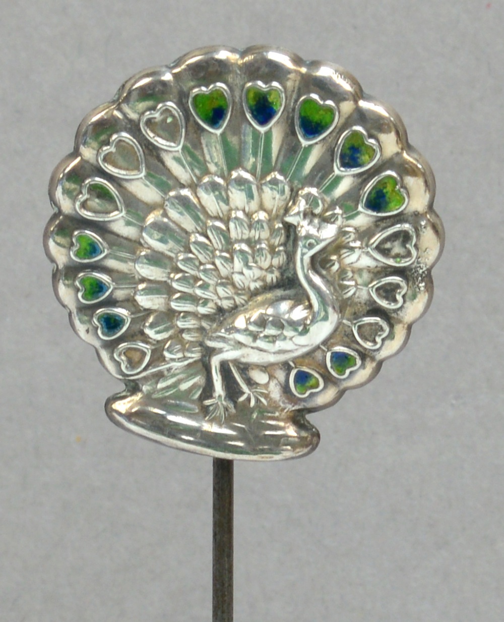 An Edward VII hallmarked silver hat pin in the form of a peacock with residual enamel to the eyes