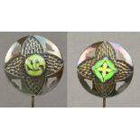 A companion pair of George V hallmarked silver Arts and Crafts circular hat pins in a stamped and