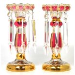 A pair of Murano cranberry colour lustres, height 28cm.