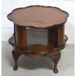 A revolving walnut occasional table with shaped top on pad feet,