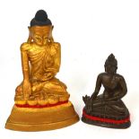 Two decorative metal models of Buddha, the largest being a gilt heightened example, height 23cm.