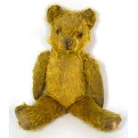 An early 20th century straw filled teddy bear, length 38cm.