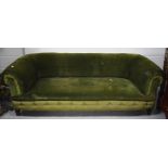 An early 20th century roll back sofa upholstered in forest green velvet on bracket feet,