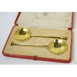 A cased pair of George V hallmarked silver gilt anointing spoons engraved '19th April 1928' verso,