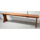 A pitch pine refectory table on slab supports,