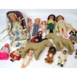 A collection of costume dolls c1950s, a doll in carrycot, Sindy dolls and two straw filled dogs.