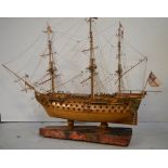 A scratch built model of 'H.M.S. Victory' mounted on a section of oak removed from H.M.S.