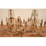 A pair of yellow metal and cut glass eight branch chandeliers,