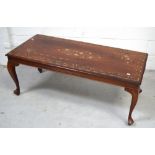 An Indian hardwood coffee table inlaid with floral and scrolling designs in brass on cabriole legs,