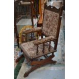 A stained wood upholstered rocking chair.