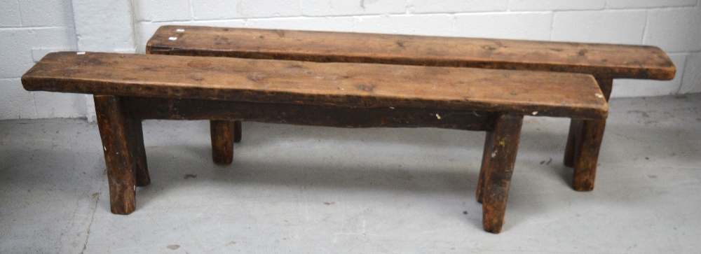 A pair of 19th century pine provincial kitchen benches on slab supports, length 168cm.