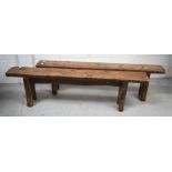 A pair of 19th century pine provincial kitchen benches on slab supports, length 168cm.