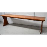 A pitch pine refectory table on slab supports,