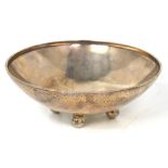 A George V hallmarked silver hammered circular bowl on four ball feet, Birmingham 1935,