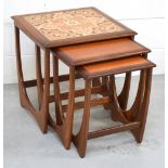 A retro nest of three G-Plan teak tables, the largest table with tiled top,