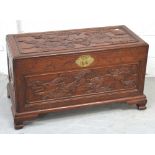 An Oriental carved camphor wood chest on bracket feet with brass fittings, length 93cm.