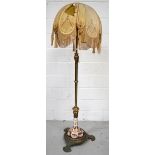An early 20th century brass standard lamp with Oriental ceramic decoration to the base,