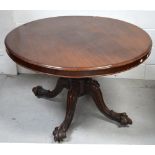 A Victorian mahogany loo table on a carved baluster base with quatrefoil curving supports to claw