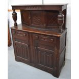 An early 20th century oak court cupboard with central upper cupboard over two drawers and two