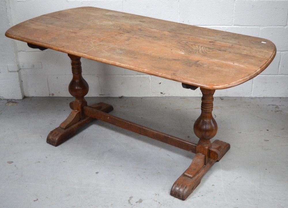 A mid 20th century oak refectory style table on carved baluster supports and stretcher,