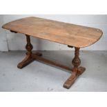 A mid 20th century oak refectory style table on carved baluster supports and stretcher,