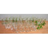 A quantity of drinking glasses to include green stemmed wine glasses, brandy glasses etc.