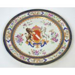 An early 19th century armorial plate painted with enamels in the Famille Rose palette with central