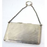 An Edward VII hallmarked silver engine turned card case with chain handle,