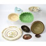 Three early 20th century jelly moulds to include a green ceramic example with rose base,