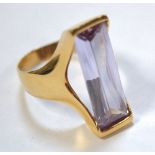 A ladies' yellow metal dress ring set with a large rectangular amethyst coloured stone, size N1/2.