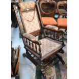 A c1900 stained wood upholstered rocking chair.