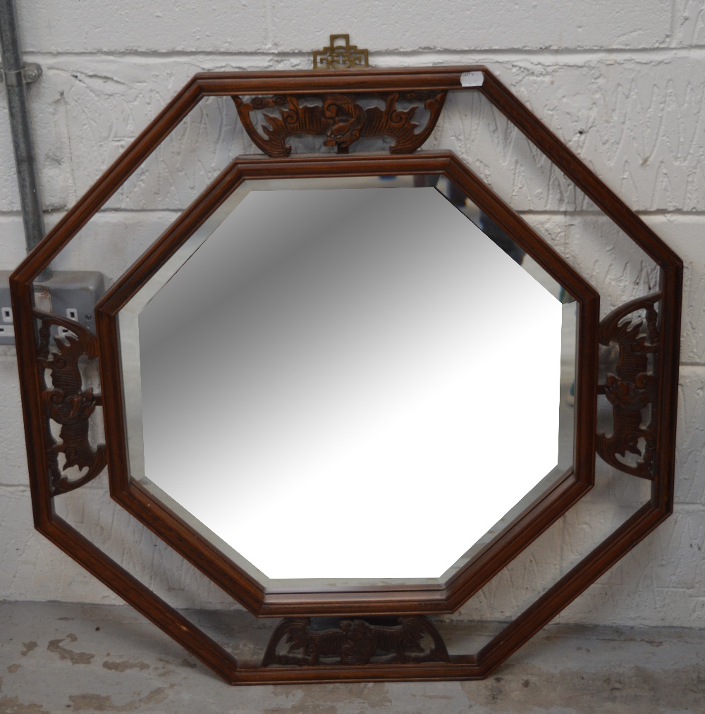 A Chinese carved octagonal wall mirror with bevelled plate, width 79cm.