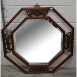 A Chinese carved octagonal wall mirror with bevelled plate, width 79cm.