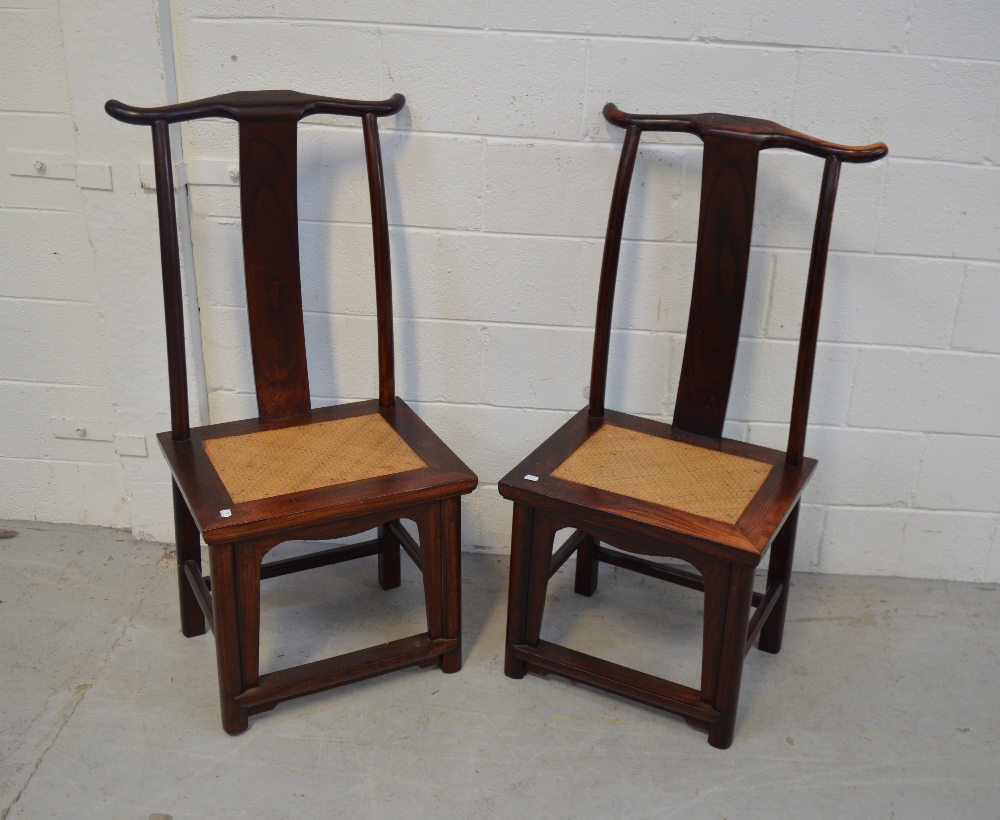 A pair of Chinese hardwood altar chairs with rattan seats.