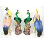 A pair of continental ceramic models of cockatoos and a similar pair of decorative ceramic peacocks,