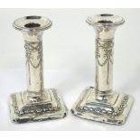 A pair of Edward VII hallmarked silver weighted candlesticks with ribbon and swag decoration,