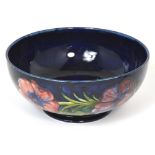 A blue ground Moorcroft bowl decorated in the anemone pattern bearing green painted signature and