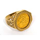 An Elizabeth II full sovereign ring set in a scrolling mount, size T 1/2, approx 9.6g.