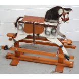 A dappled grey painted wooden rocking horse with a fitted saddle and real horse hair mane and tail,