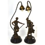 A pair of spelter figural table lamps on rounded ebonised bases,