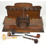 An oak smoker's compendium with pipe rack back and five pipes to include one Adyin example and a