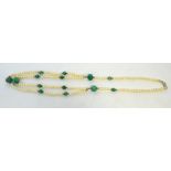 A freshwater pearl and emerald necklace with silver clasp and silver beads.