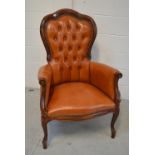 A walnut leather upholstered tub chair.