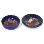 Two blue ground Moorcroft dishes decorated in the anemone pattern, one with footed base,